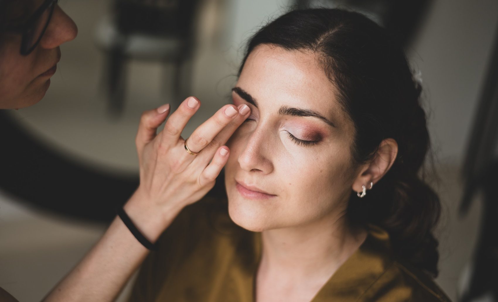 Eye shadow being blended on a bride's eyelid