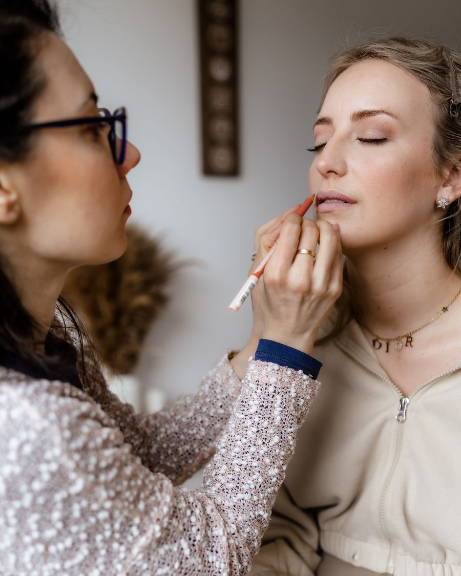 A bride's lips being painted with a fine brush
