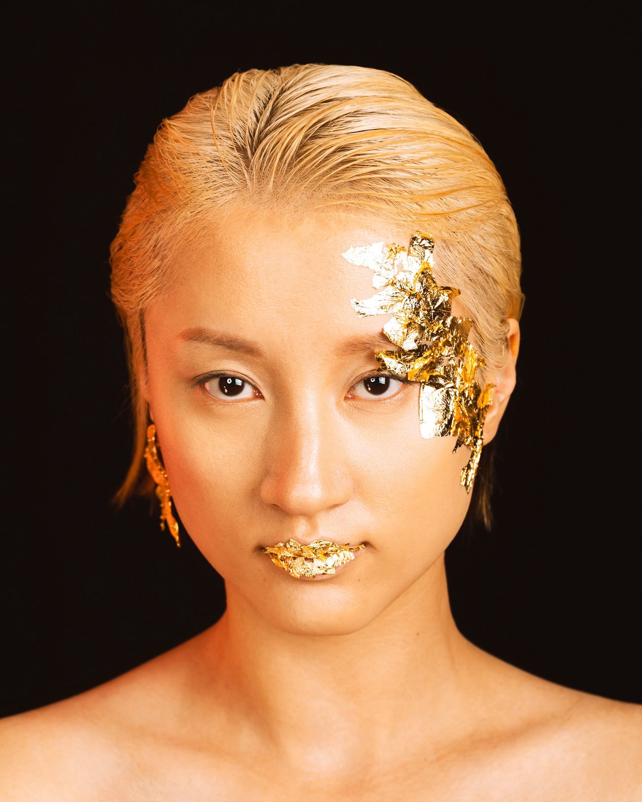 Portrait with gold leaf over one eye, on the lips and in the hair