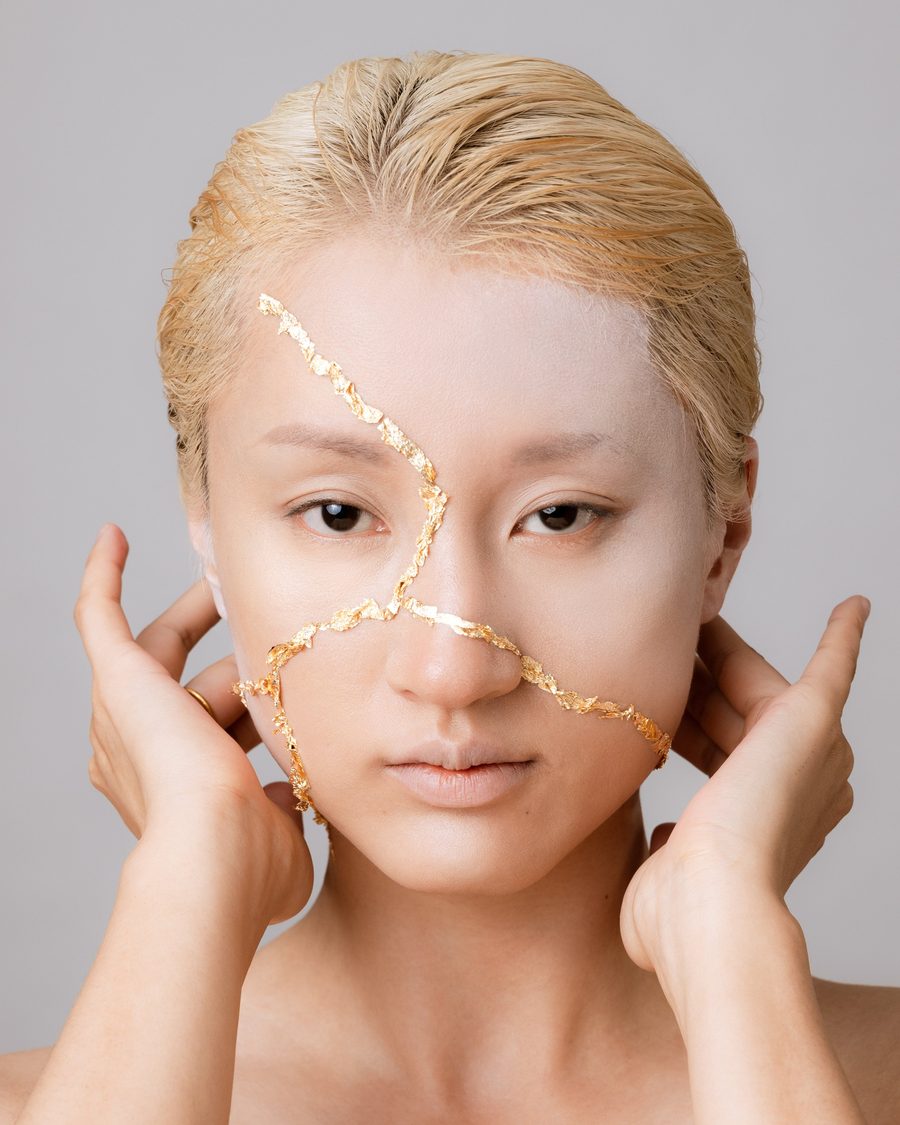 Portrait with fine gold lines running across a pale face