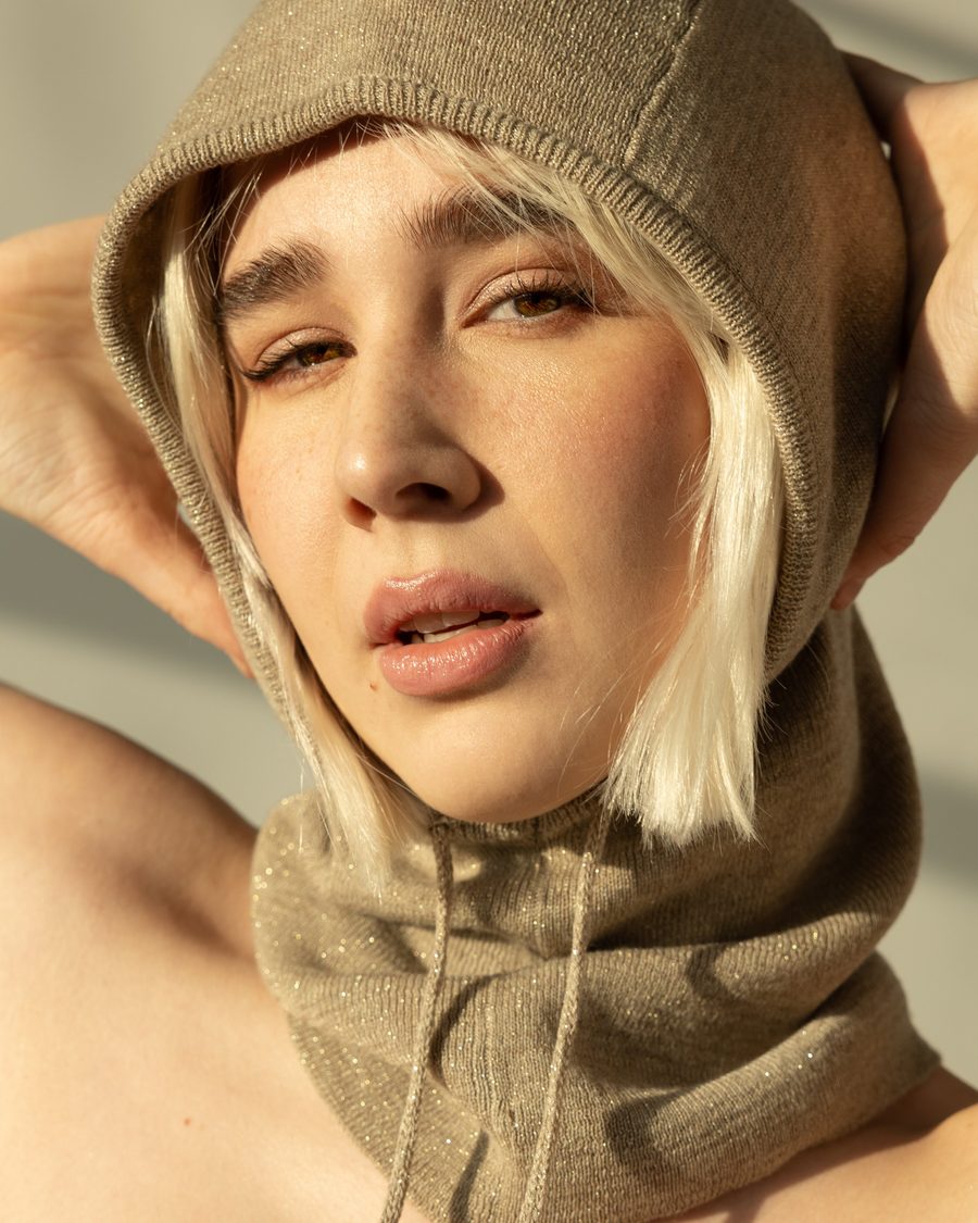 Woman with a blonde bob in a knitted hood