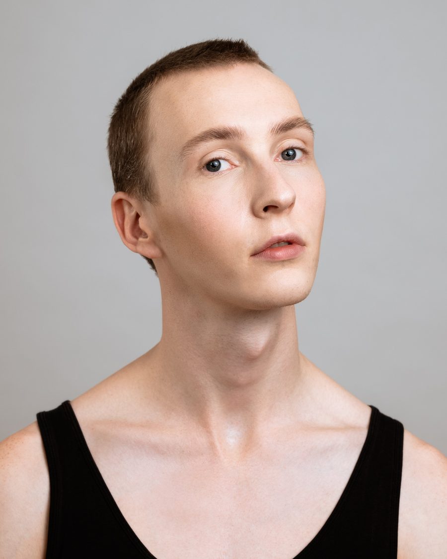 Portrait of a young man in a black vest, clean skin
