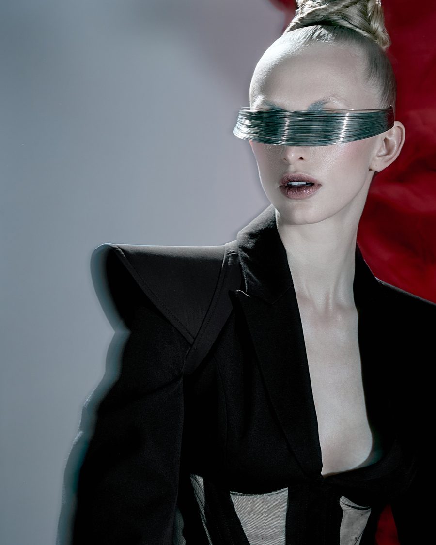 Woman in a black jacket with a strip of clear foil across her eyes